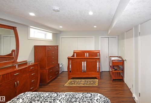 Wood-finish flooring, recessed lighting, and a white-framed egress window - 9657 68A Street Nw, Edmonton, AB 