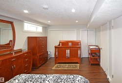 Wood-finish flooring, recessed lighting, and a white-framed egress window - 