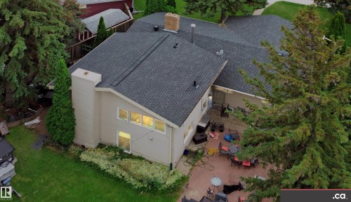 Multi-level asphalt shingle roof with a prominent brick chimney - 9657 68A Street Nw, Edmonton, AB 