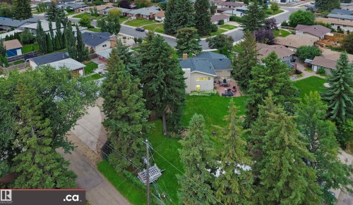 Mature tree-lined lot featuring a stucco exterior and backyard patio - 9657 68A Street Nw, Edmonton, AB 