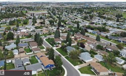 Residential neighborhood featuring mature trees, paved streets, and a mix of single-story homes - 
