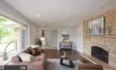 Stone-clad fireplace with hearth, wood-finish flooring, recessed lighting, and sliding glass door - 9657 68A Street Nw, Edmonton, AB 