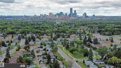 Expansive neighborhood setting featuring a dense tree canopy and a distant urban skyline - 