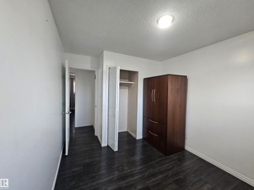 Dark wood-finish flooring with white walls and a ceiling-mounted light fixture - 8828 151 Avenue Northwest, Edmonton, AB 