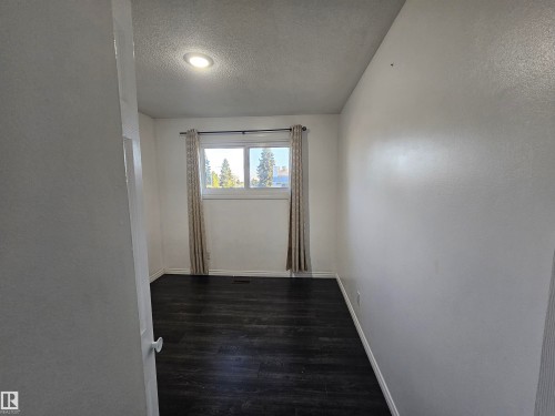 Recessed ceiling lighting, a window with exterior scenery, wood-finish flooring, and white painted walls - 8828 151 Avenue Northwest, Edmonton, AB 