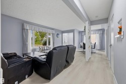 Light wood-finish flooring throughout, bright window with drapes, and an open layout with structural pillar - 