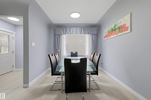 Recessed ceiling with an overhead light fixture, light-toned wood-finish flooring, and a white interior door with frosted glass panels - 13024 Sherbrooke Avenue Nw, Edmonton, AB 