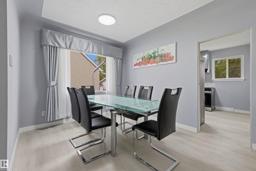 Recessed ceiling light, light wood-finish flooring, and a window with custom drapery - 13024 Sherbrooke Avenue Nw, Edmonton, AB 