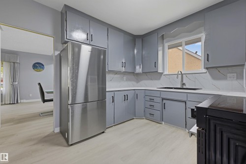 Kitchen featuring gray cabinetry, white countertops, a black sink, and light wood-finish flooring - 13024 Sherbrooke Avenue Nw, Edmonton, AB 