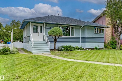Exterior featuring a light-toned stucco and horizontal siding combination - 13024 Sherbrooke Avenue Nw, Edmonton, AB 