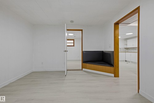 Light wood-finish flooring with white walls and ceiling paneling - 13024 Sherbrooke Avenue Nw, Edmonton, AB 