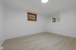 Room featuring light wood-finish flooring, white paneled walls, and a recessed window with wood trim - 