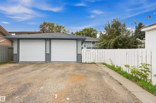 Two-car detached garage with white panel doors and a shingle roof - 13024 Sherbrooke Avenue Nw, Edmonton, AB 