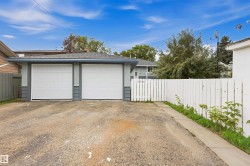 Two-car detached garage with white panel doors and a shingle roof - 