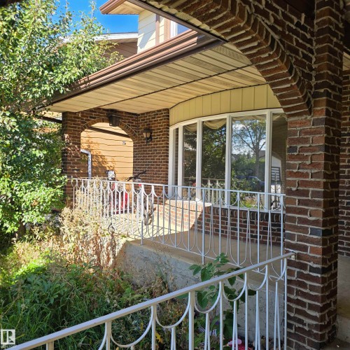 Brick exterior with an arched entryway and a bay window - 11022 158 Avenue Nw, Edmonton, AB 