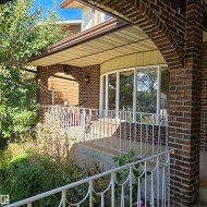Brick exterior with an arched entryway and a bay window - 