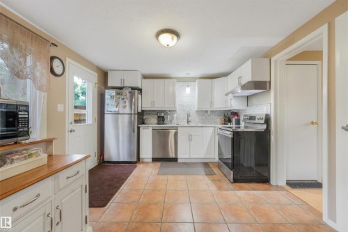 Large Kitchen Space featuring modern white and grey backsplash, stainless steel appliances, butcher block moveable island, and BRAND NEW COUNTERTOPS! - 267 Ridgewood Terrace, St. Albert, AB - Indoor Photo Showing Kitchen With Stainless Steel Kitchen