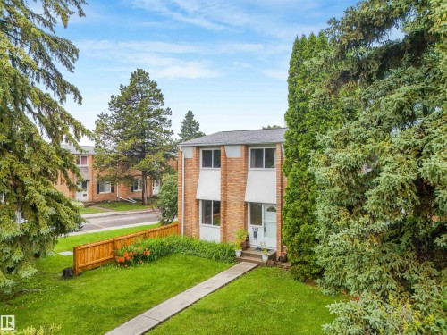 Front of home featuring vinyl siding and brick exterior, mature trees, and walking path leading to home. - 267 Ridgewood Terrace, St. Albert, AB - Outdoor