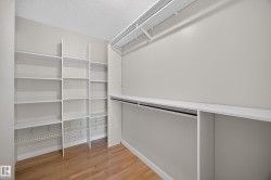 Walk-In Closet.  Custom built-in shelving, integrated hanging rods, and wood-finish flooring. - 