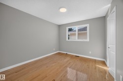Bedroom 2.  Hardwood flooring, painted walls, white trim, single window, and a flush mount ceiling light - 