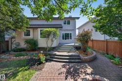 Exterior featuring a multi-level deck, bay window, and a paver stone pathway - 
