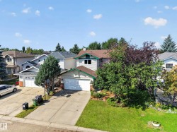 Attached two-car garage, concrete driveway, and established front landscaping - 