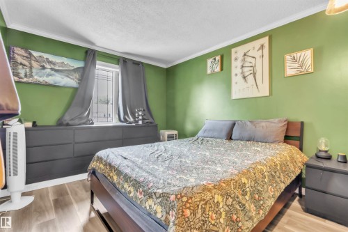 Bedroom featuring wood-finish flooring, a window with curtains, and crown molding - 5103 50 Street, Cold Lake, AB - Indoor Photo Showing Bedroom