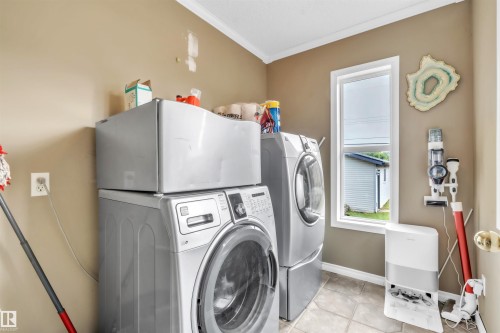 Dedicated laundry area featuring a tiled floor, neutral wall tones, and a window providing natural light - 5103 50 Street, Cold Lake, AB - Indoor Photo Showing Laundry Room