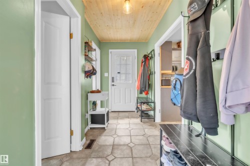 Entryway with patterned floor tiles, plank wood-finish ceiling, and light green walls - 5103 50 Street, Cold Lake, AB - Indoor