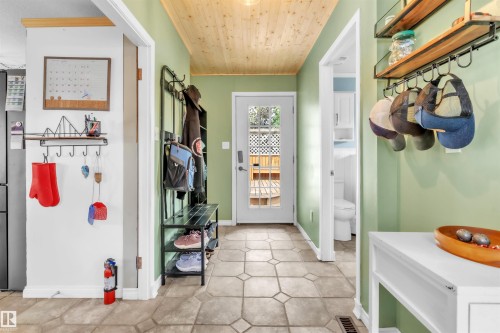 Entryway featuring wood-finish ceiling, patterned tile flooring, and a glass-paneled exterior door - 5103 50 Street, Cold Lake, AB - Indoor Photo Showing Other Room