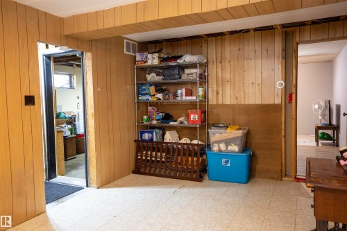 Paneling walls with an exposed ceiling beam and patterned tile flooring - 10428 68 Avenue Nw, Edmonton, AB 