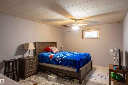 Room with light gray walls, a window with wood trim, and a ceiling fan with integrated lighting - 10428 68 Avenue Nw, Edmonton, AB 
