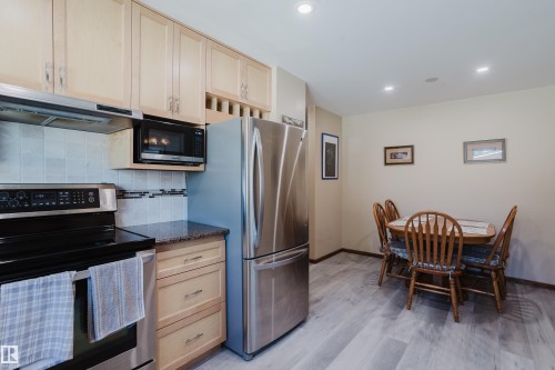 Recessed lighting illuminates the kitchen and dining area with wood-finish flooring - 10924 35A Avenue Nw, Edmonton, AB 