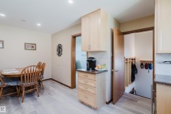 Recessed lighting illuminates the dining area, featuring wood-finish flooring - 