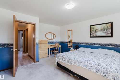 Neutral wall paint with a contrasting accent wall, ceiling-mounted light fixture, and wood-finish doors - 10924 35A Avenue Nw, Edmonton, AB 