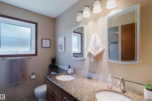Dual vanity with integrated sinks, granite-finish countertop, and brushed nickel fixtures - 10924 35A Avenue Nw, Edmonton, AB 