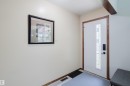 Entryway featuring a white door with decorative glass inserts, wood-finish trim, and a smart lock system - 10924 35A Avenue Nw, Edmonton, AB 