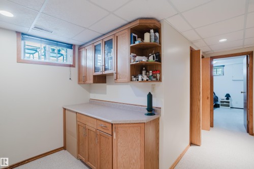 Built-in cabinetry with glass-front uppers, open shelving, and a light-toned countertop - 10924 35A Avenue Nw, Edmonton, AB 