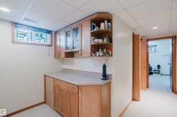 Built-in cabinetry with glass-front uppers, open shelving, and a light-toned countertop - 