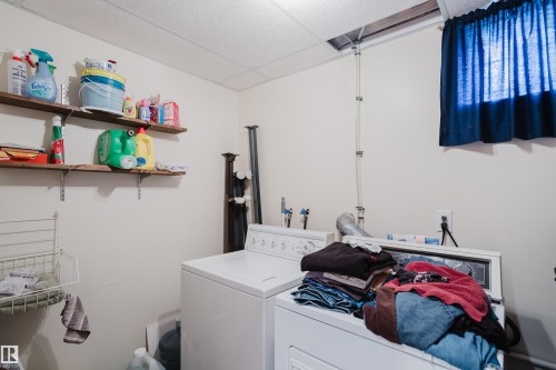 Laundry area with a washer and dryer, featuring overhead shelving - 10924 35A Avenue Nw, Edmonton, AB 