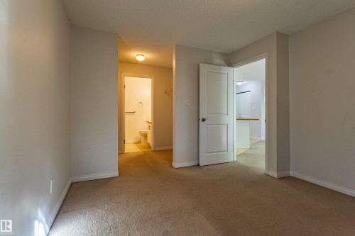Neutral wall paint, carpeted flooring, white interior doors, and overhead lighting - #316 11325 83 St Nw, Edmonton, AB 