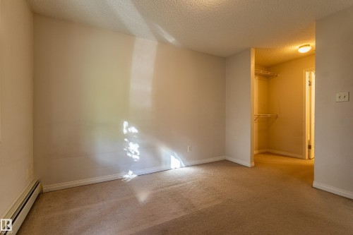 Plush carpeting, neutral wall tones, and an integrated walk-in closet with shelving - #316 11325 83 St Nw, Edmonton, AB 
