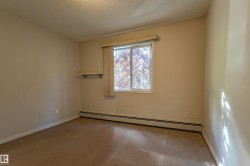 Window with a vertical blind, wall-mounted shelf, baseboard heating unit, and carpeted flooring - 