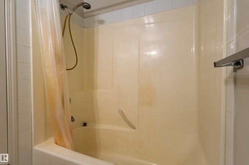 Bathtub with a wall-mounted shower head and a grab bar - #316 11325 83 St Nw, Edmonton, AB 
