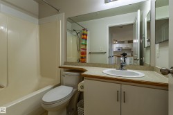 Bathroom featuring a tub/shower combination, a vanity with an integrated sink, a large wall mirror, and a toilet - 