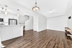 Wood-finish flooring throughout, white cabinetry, stainless steel appliances, and integrated shelving - 