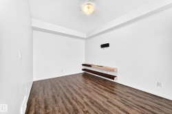 Wood-finish flooring, white walls, and a ceiling-mounted light fixture - 