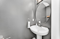 Pedestal sink with chrome fixtures and an oval mirror - 