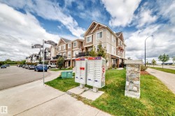 Townhome community featuring multi-level residences with balconies and a paved sidewalk - 