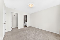 Plush carpet flooring, a flush-mount ceiling light fixture, and white painted walls - 